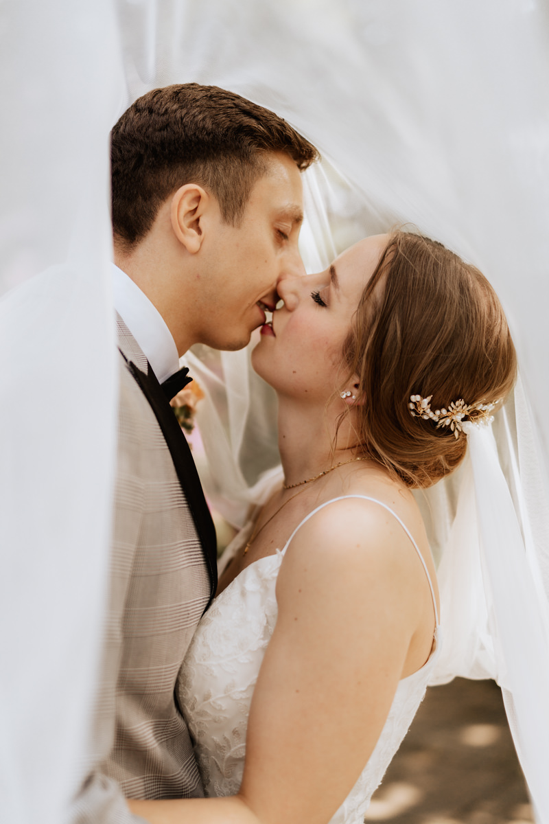 Hochzeitsfotograf Celle fotografiert küssendes Brautpaar unter Schleier